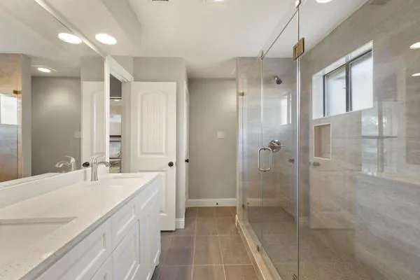 a bathroom with a double vanity sink mirror double and shower