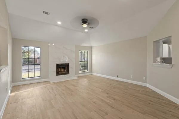 an empty room with windows and fireplace