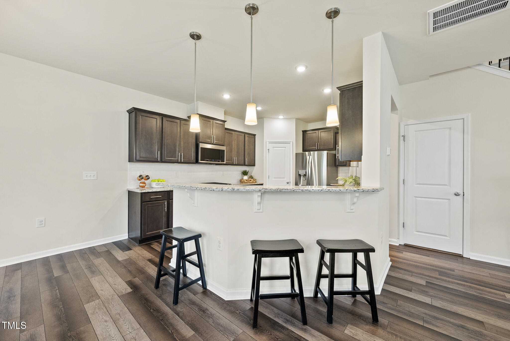 5340 Faulkner Street Durham, NC 27560 - Photo 10 of 31 a kitchen with stainless steel appliances granite countertop a kitchen island hardwood floor and a sink