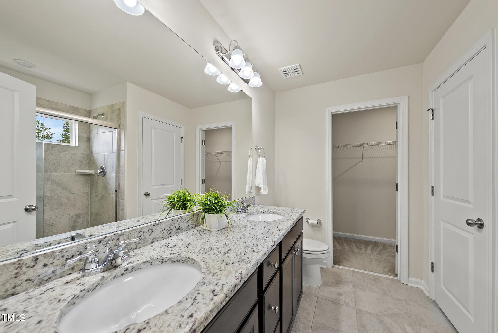 5340 Faulkner Street Durham, NC 27560 - Photo 18 of 31 a bathroom with a granite countertop sink a large mirror and a shower