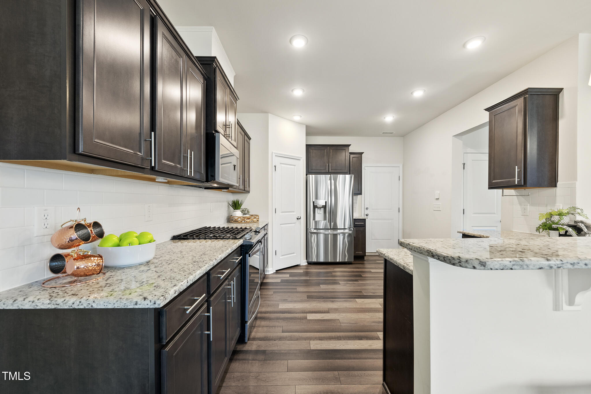 5340 Faulkner Street Durham, NC 27560 - Photo 4 of 31 a kitchen with granite countertop stainless steel appliances and wooden floor