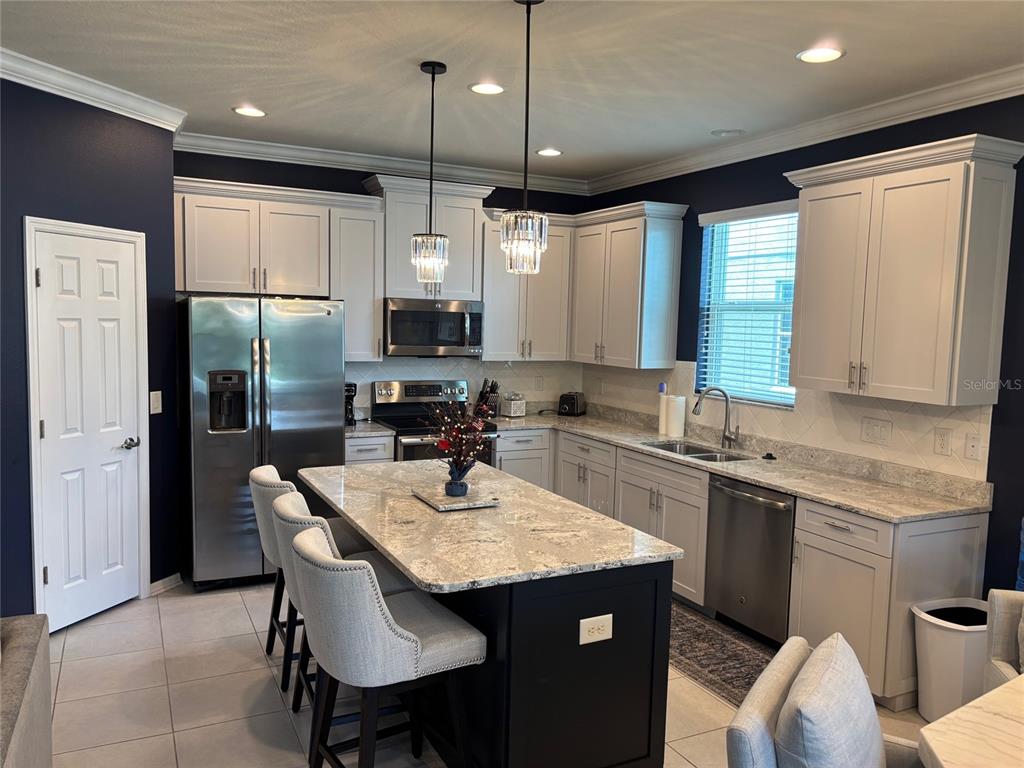 10915 79th Street East Parrish, FL 34219 - Photo 3 of 27 a kitchen with kitchen island granite countertop a sink a center island and stainless steel appliances