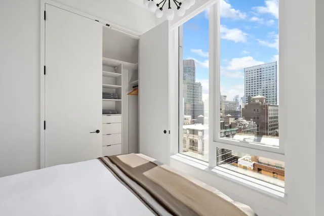 a bedroom with a bed and next to a window