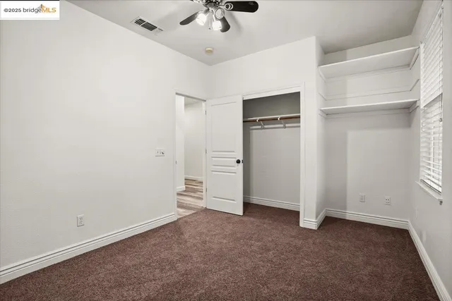 a view of empty room with wooden floor and windows