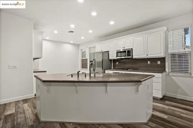 a kitchen with kitchen island stainless steel appliances a sink and a stove