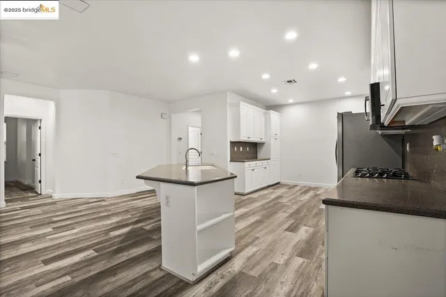 a kitchen with kitchen island a sink appliances and cabinets
