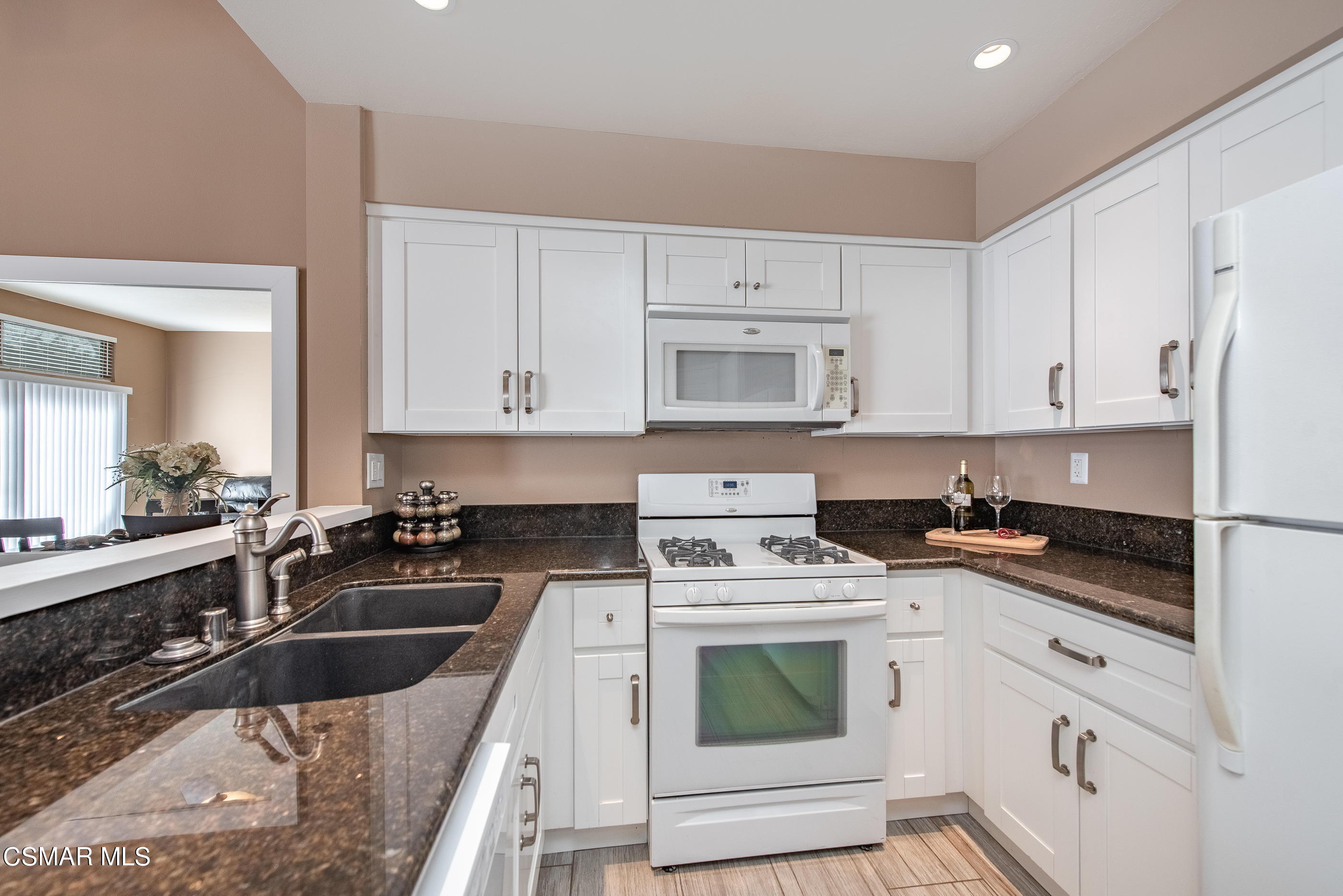 1736 Sinaloa Road, Unit 315 Simi Valley, CA 93065 - Photo 8 of 31 a kitchen with granite countertop a sink a stove a refrigerator and cabinets