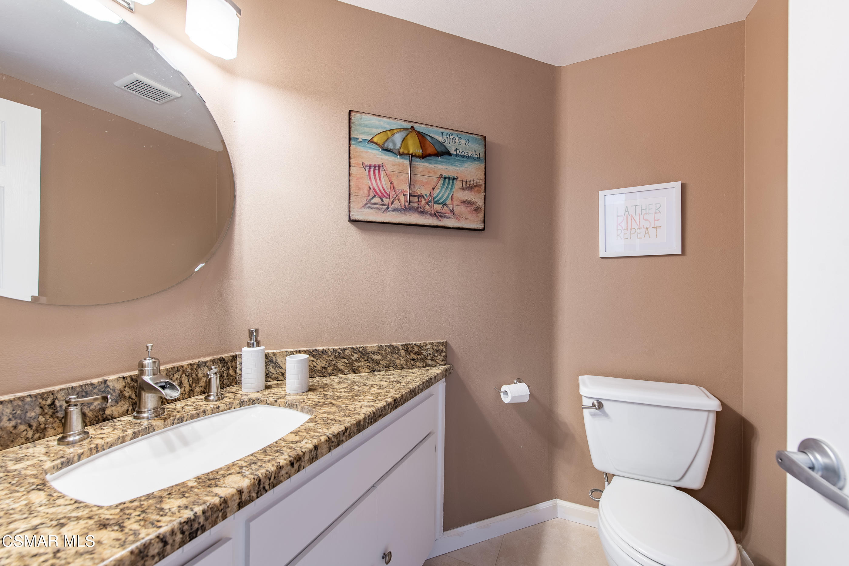 1736 Sinaloa Road, Unit 315 Simi Valley, CA 93065 - Photo 10 of 31 a bathroom with a granite countertop toilet a sink and a mirror