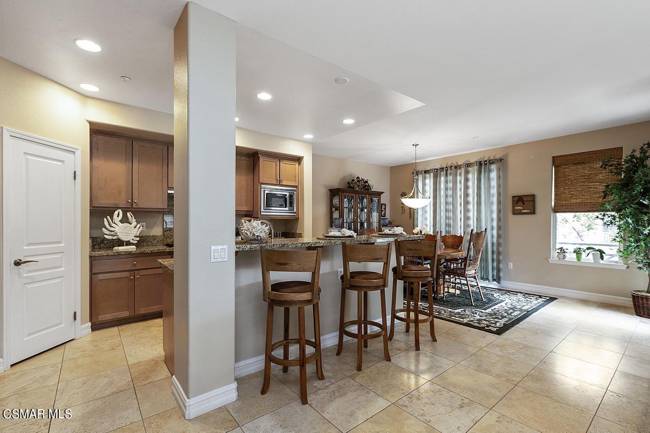 1501 Windshore Way Oxnard, CA 93035 - Photo 5 of 24 a kitchen with stainless steel appliances kitchen island granite countertop a table and chairs in it