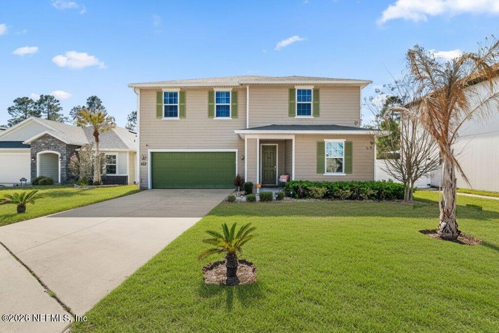 a front view of a house with a yard and garage