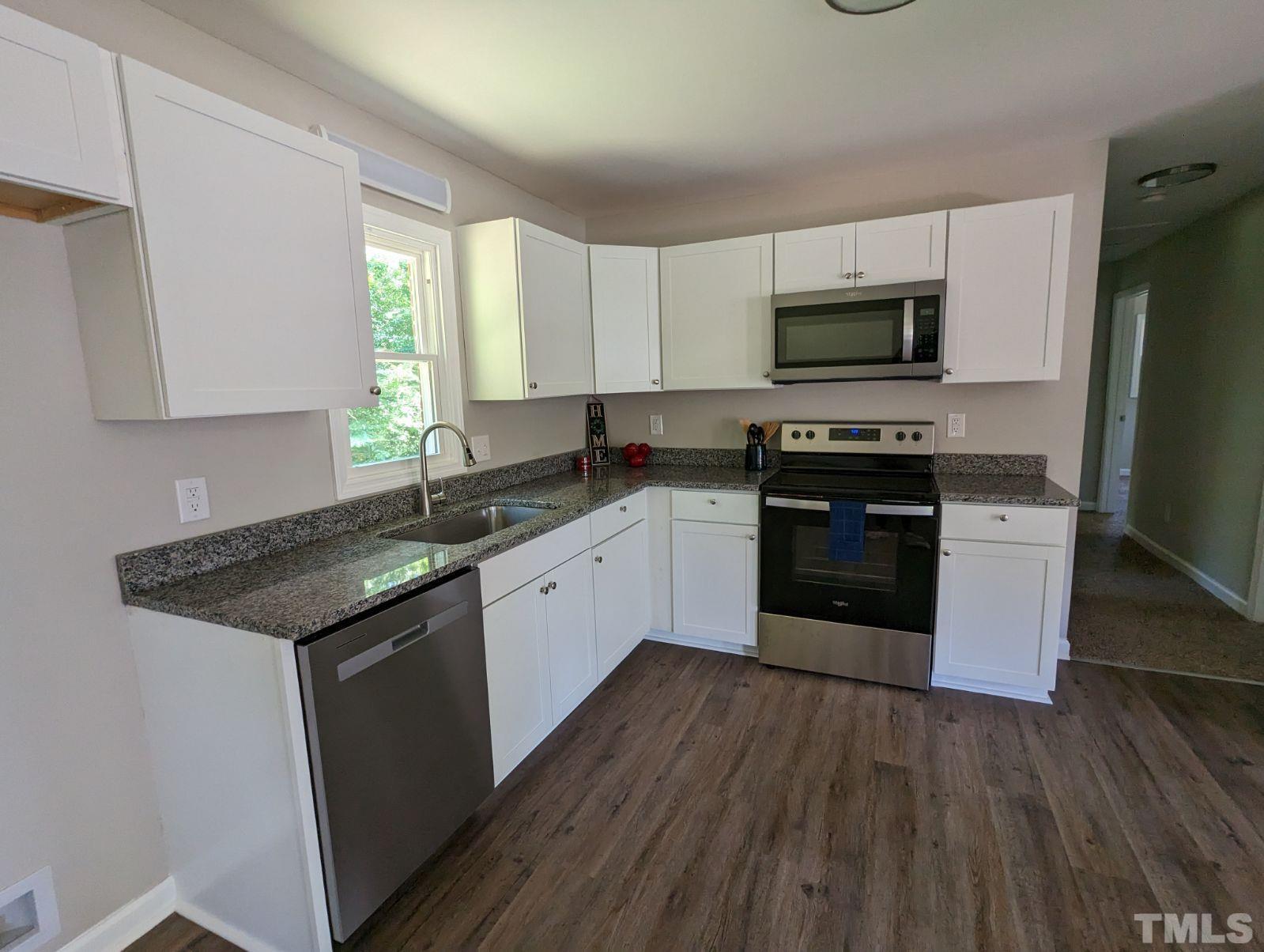30 Alton Acres Subdivision Road Louisburg, NC 27549 - Photo 13 of 35 a kitchen with stainless steel appliances granite countertop wooden cabinets a sink a stove a refrigerator and microwave
