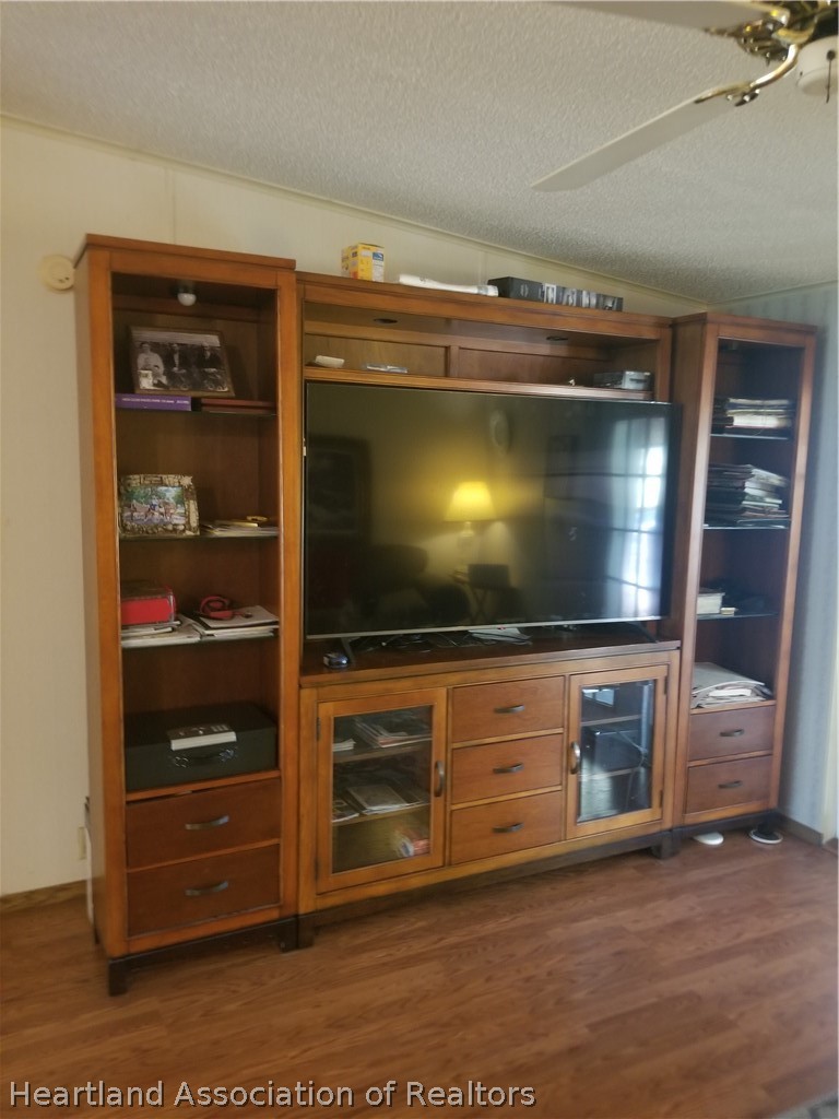 9125 Spur Path Sebring, FL 33875 - Photo 12 of 31 Large, beautiful TV console in living room with 65 inch TV. They both stay with the house!
