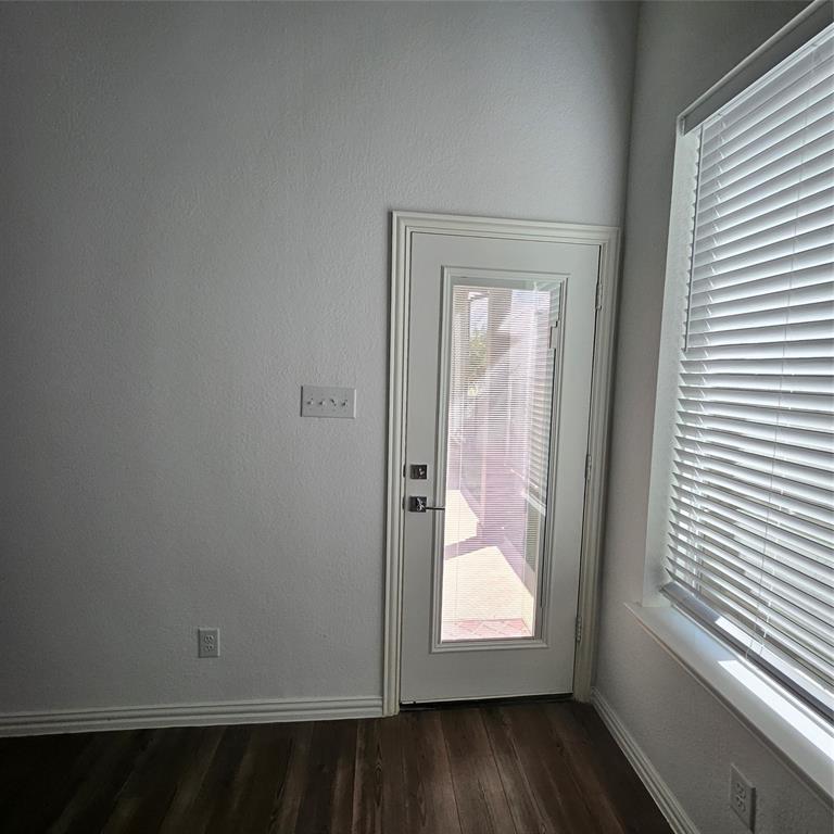 2309 Jack Rabbit Way Northlake, TX 76247 - Photo 6 of 28 Wood-finish flooring with white baseboards, a white door frame, and a glass-paneled door