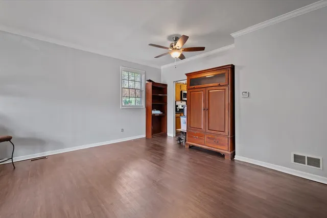 a view of an empty room with window and wooden floor