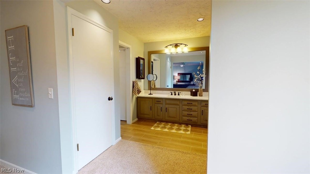 3985 Wiers Road Willard, OH 44890 - Photo 25 of 50 Wide vanity with a large framed mirror, heated flooring, integrated lighting, and a light-colored countertop