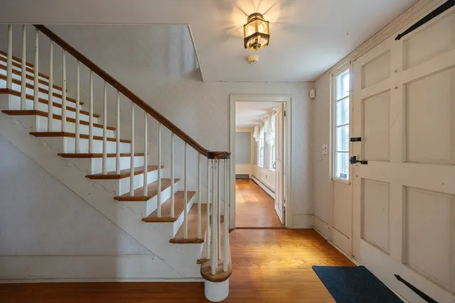 a view of entryway and hall with wooden floor