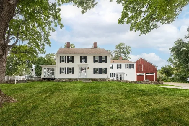 a view of a house with a big yard and large trees