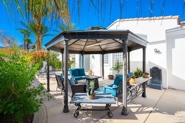 a view of a patio with a table and chairs under an umbrella