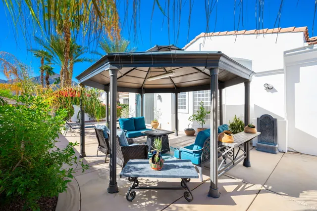 a view of a patio with a table and chairs under an umbrella