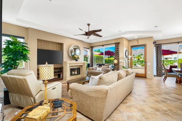 a living room with furniture a fireplace and a potted plant