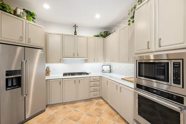 a kitchen with white cabinets and stainless steel appliances