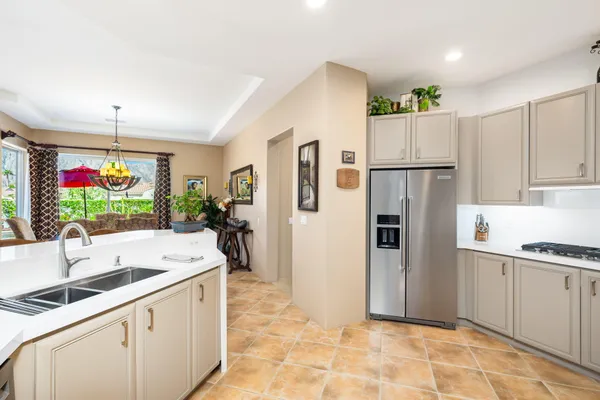 a kitchen with white cabinets a counter top space and stainless steel appliances
