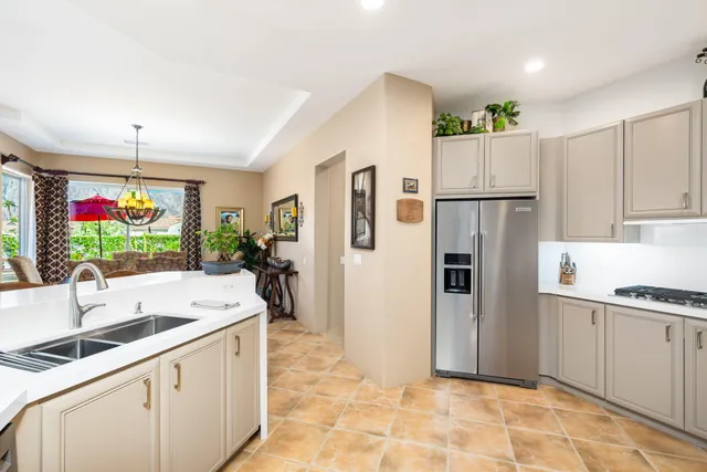 a kitchen with white cabinets a counter top space and stainless steel appliances