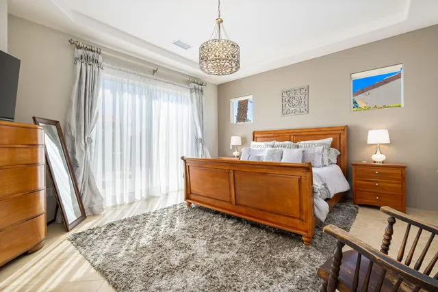 a bedroom with a bed and a chandelier