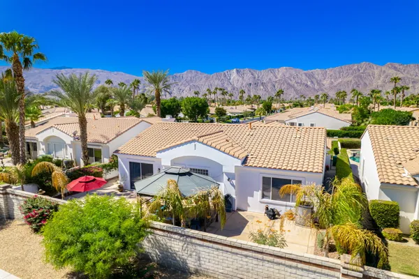a front view of a house with a yard and mountain view