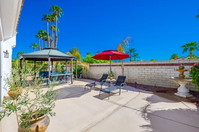 a view of a patio with a table and chairs under an umbrella