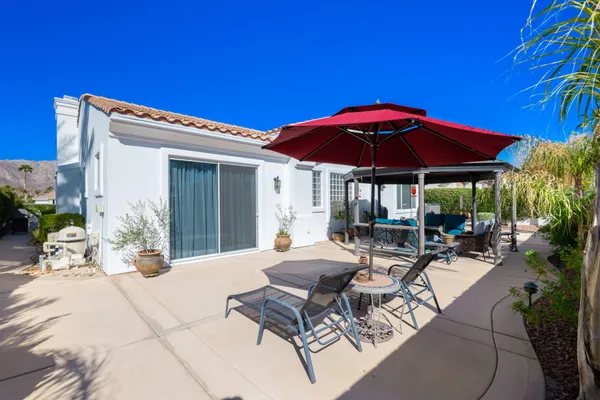 a view of a patio with chairs and umbrellas
