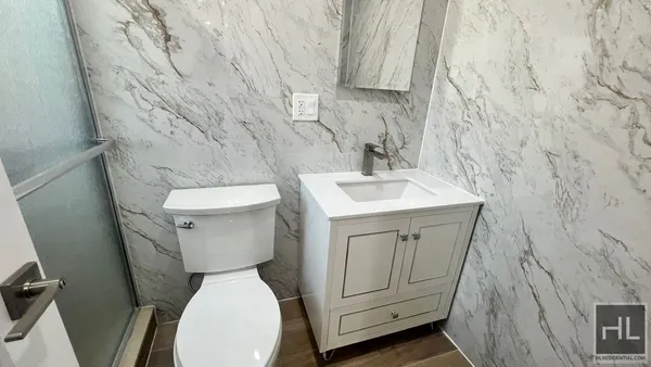 a white toilet sitting next to a white sink and vanity