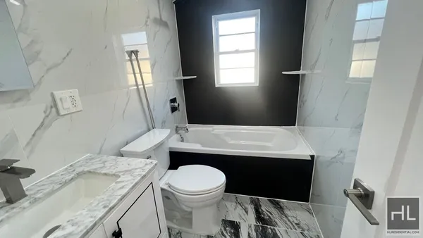 a bathroom with a granite countertop toilet sink and mirror