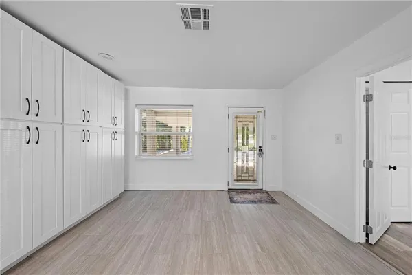 a kitchen with white cabinets appliances a sink and a window
