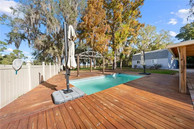 a view of house with backyard and trees in the background