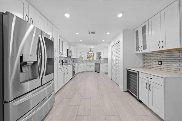 a kitchen with granite countertop white cabinets and white stainless steel appliances