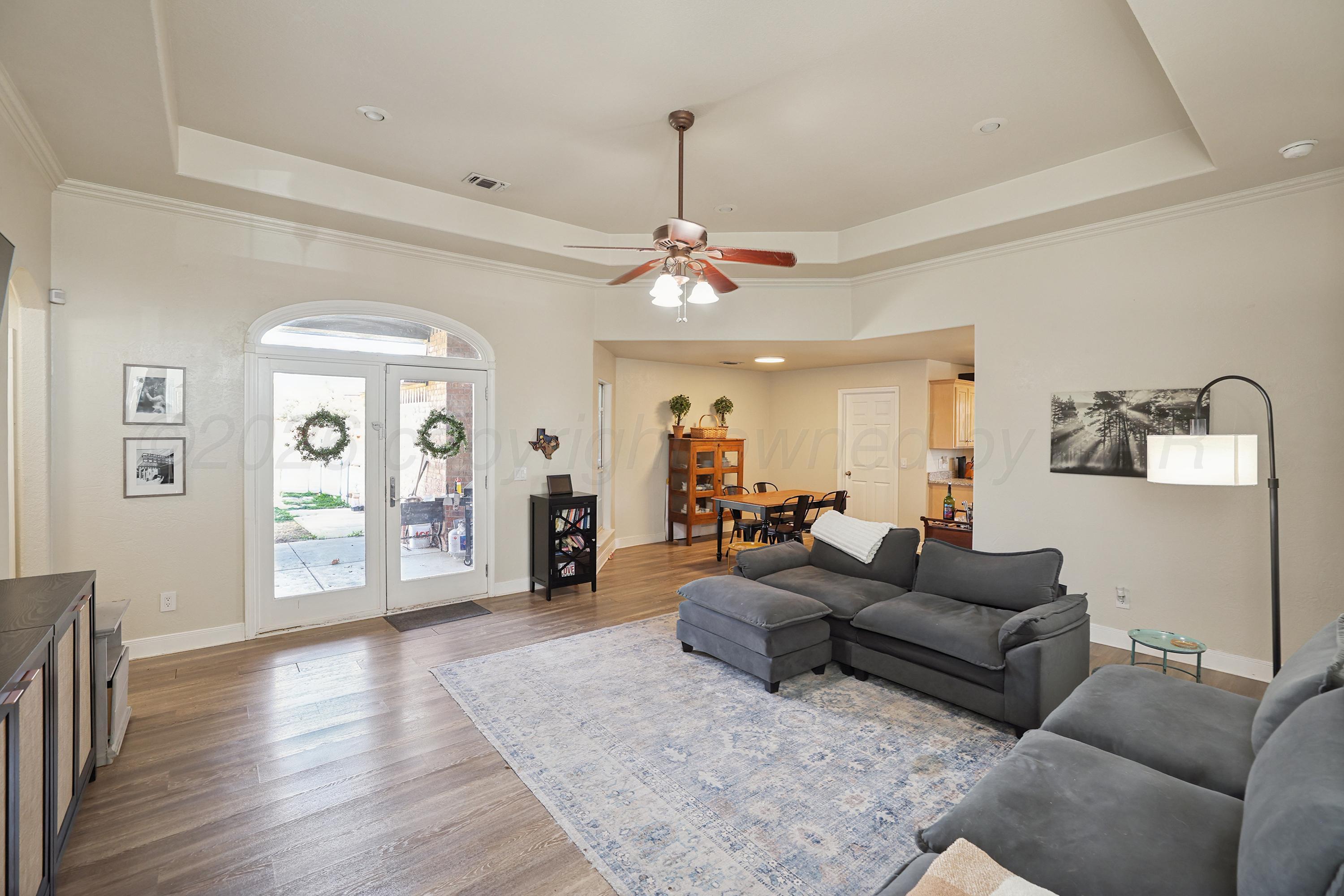 6400 Rally Road Amarillo, TX 79119 - Photo 3 of 21 a living room with furniture a wooden floor and a chandelier