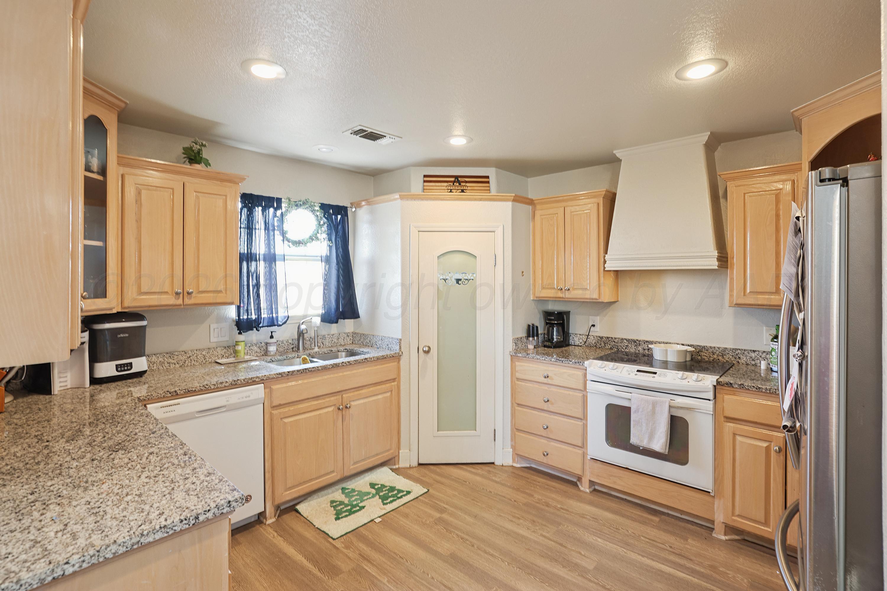 6400 Rally Road Amarillo, TX 79119 - Photo 6 of 21 a kitchen with stainless steel appliances granite countertop a stove a sink and a refrigerator