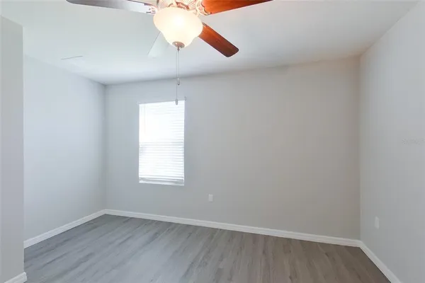 an empty room with a window and wooden floor