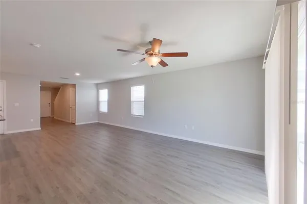 a view of a room with wooden floor and a ceiling fan