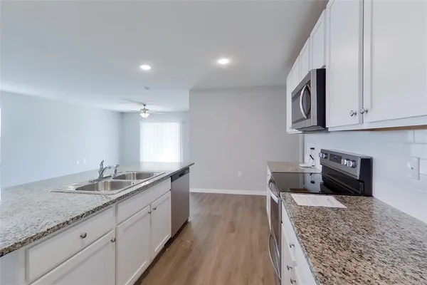 a kitchen with granite countertop a sink and a stove top oven