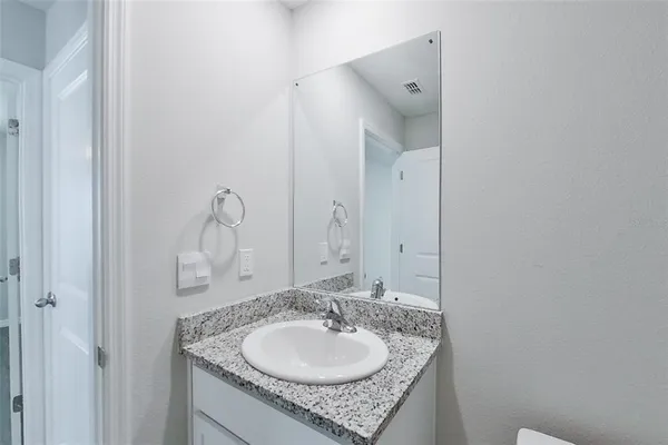 a bathroom with a granite countertop sink and a mirror