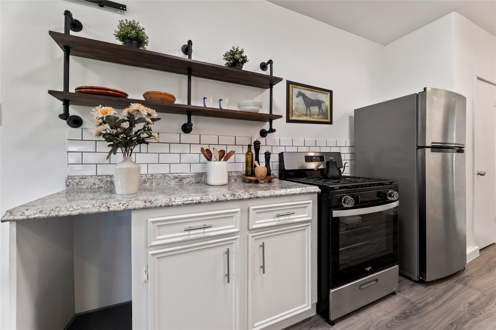 1010 Long Street Conroe, TX 77301 - Photo 11 of 26 a kitchen with stainless steel appliances granite countertop a refrigerator and a sink