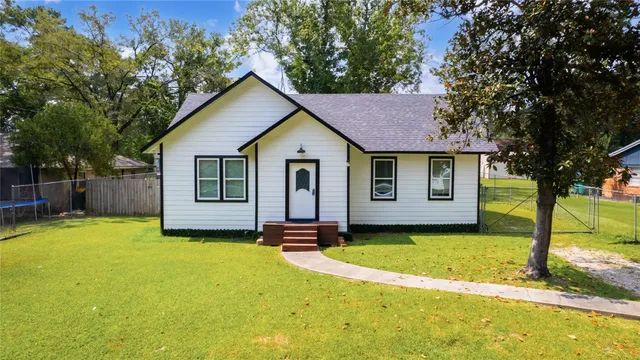 a view of a house with a yard and tree