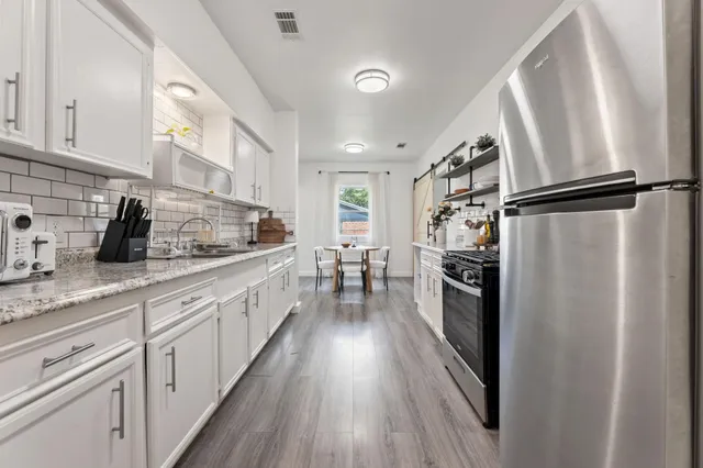a kitchen with granite countertop white cabinets white appliances and sink