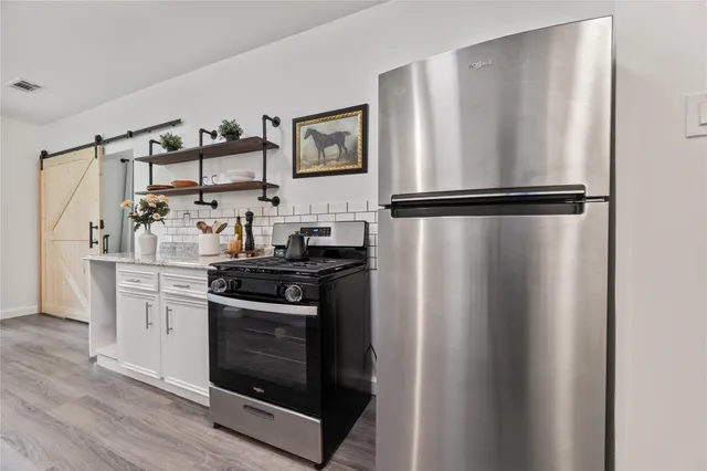 a kitchen with granite countertop white cabinets white appliances and sink