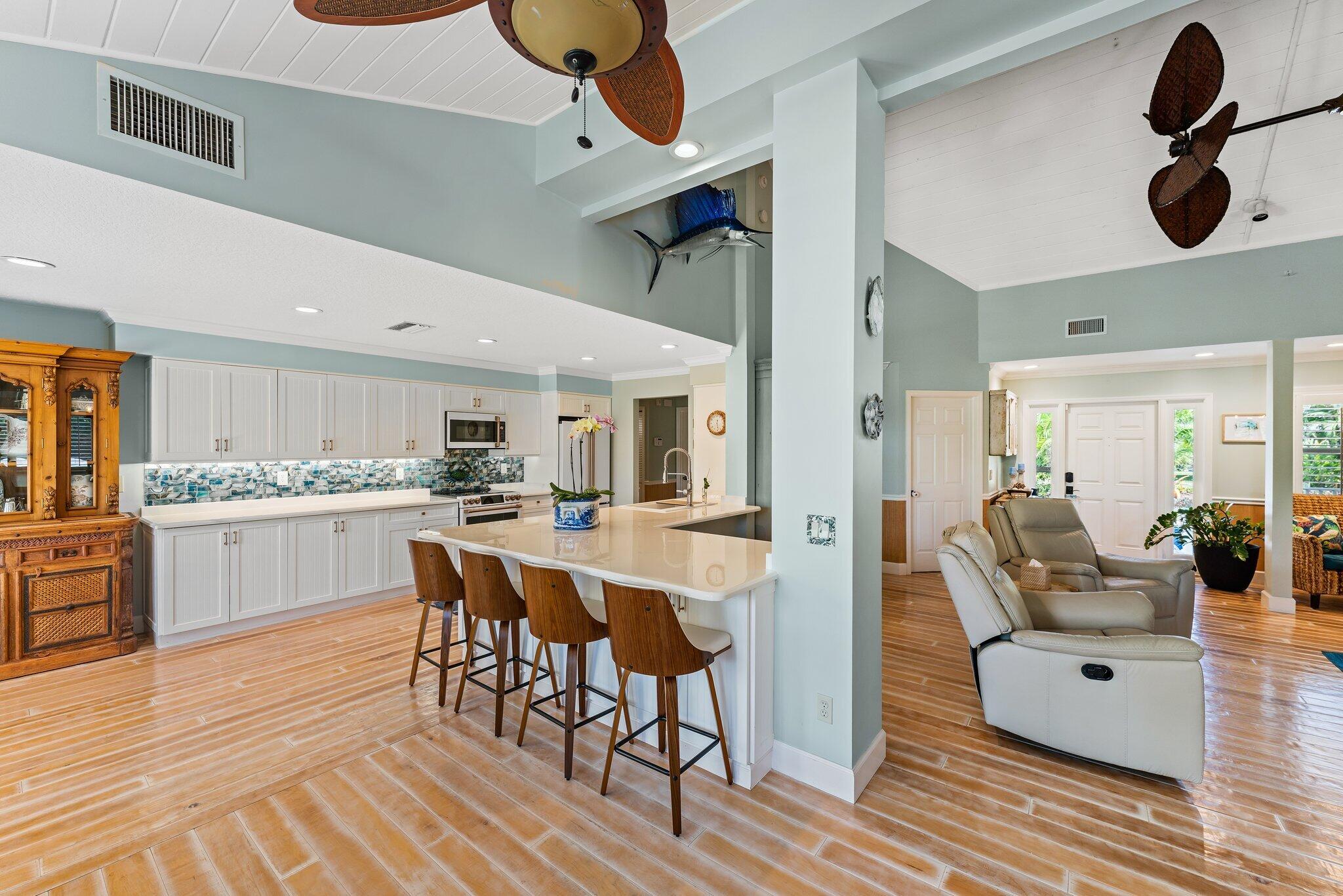4120 Southeast Whiticar Way Stuart, FL 34997 - Photo 20 of 60 a kitchen with stainless steel appliances kitchen island granite countertop a table and chairs in it