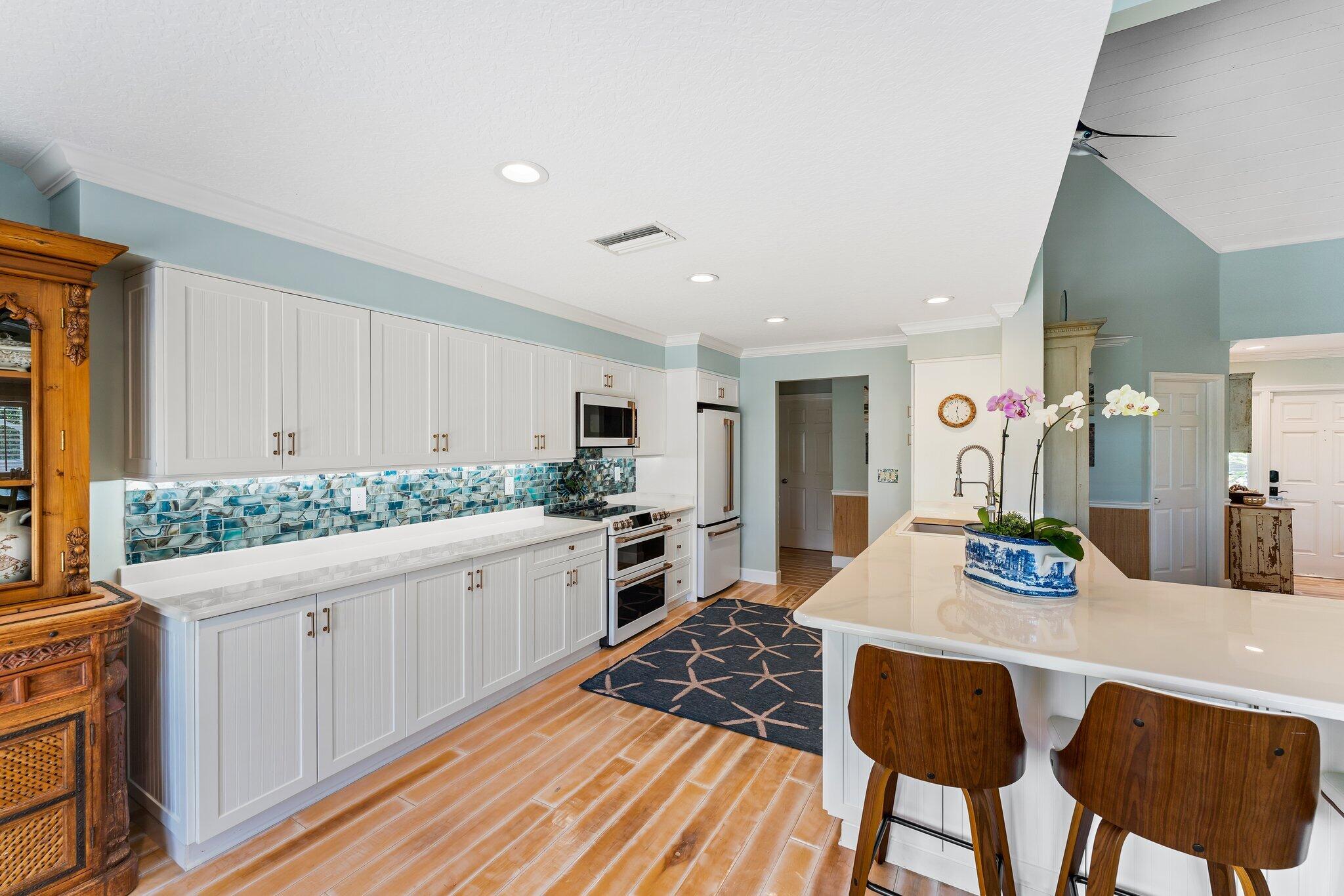 4120 Southeast Whiticar Way Stuart, FL 34997 - Photo 21 of 60 a kitchen with granite countertop sink stove and white cabinets