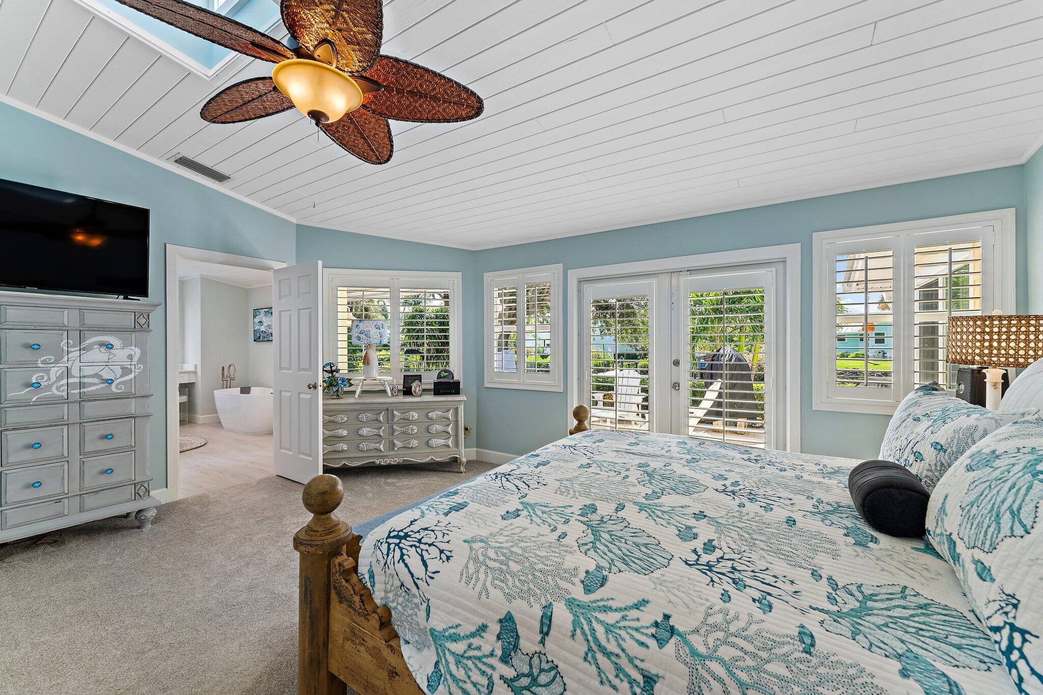 4120 Southeast Whiticar Way Stuart, FL 34997 - Photo 26 of 60 a bedroom with a large bed and a flat tv screen