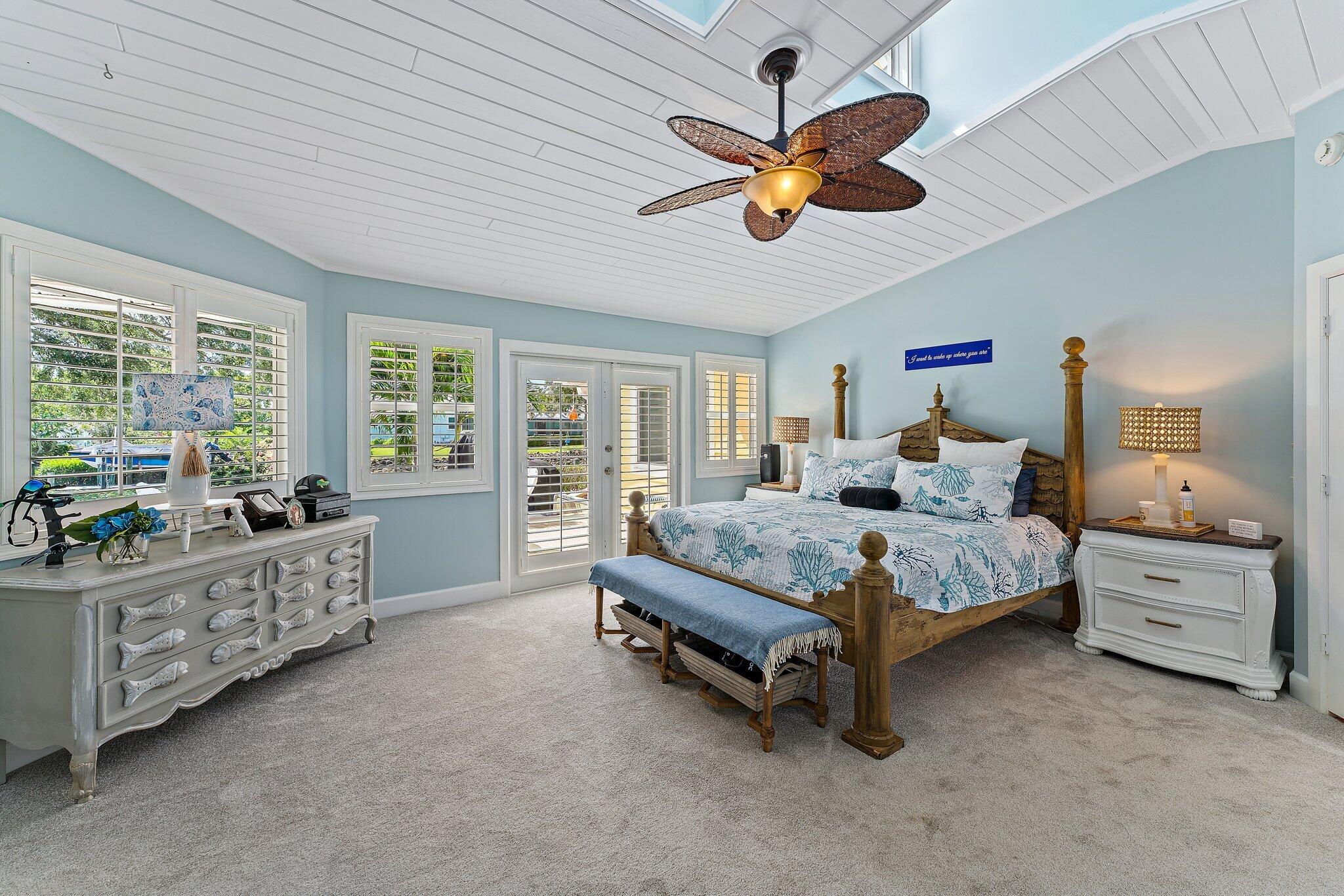 4120 Southeast Whiticar Way Stuart, FL 34997 - Photo 27 of 60 a bedroom with a bed and a chandelier